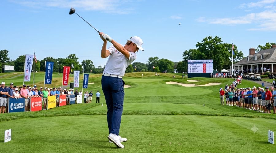 A young golfer swinging a club on a green course during an amateur tournament