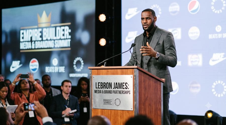 LeBron James standing at a podium discussing his media production ventures and brand partnerships
