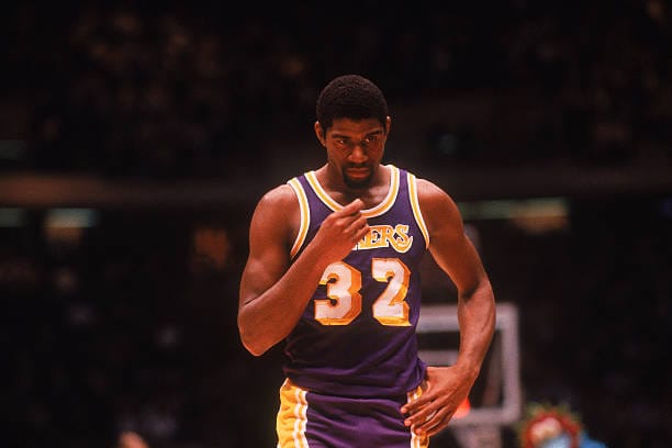 Center Magic Johnson #32 of the Los Angeles Lakers walks on the court circa the 1980's during a game against the Philadelphia Sixers. 